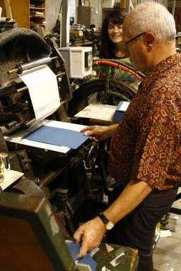 Poet Jennifer Liston watches Charles Zammit binding and stamping her second poetry collection